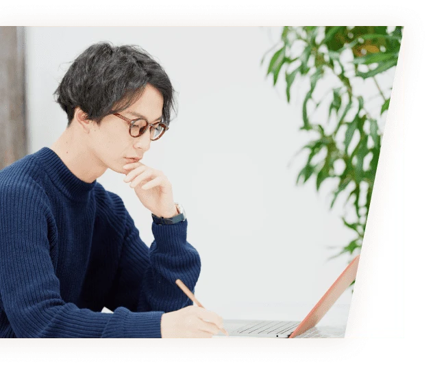 男性社員が口に指を当て、考え事をしている様子